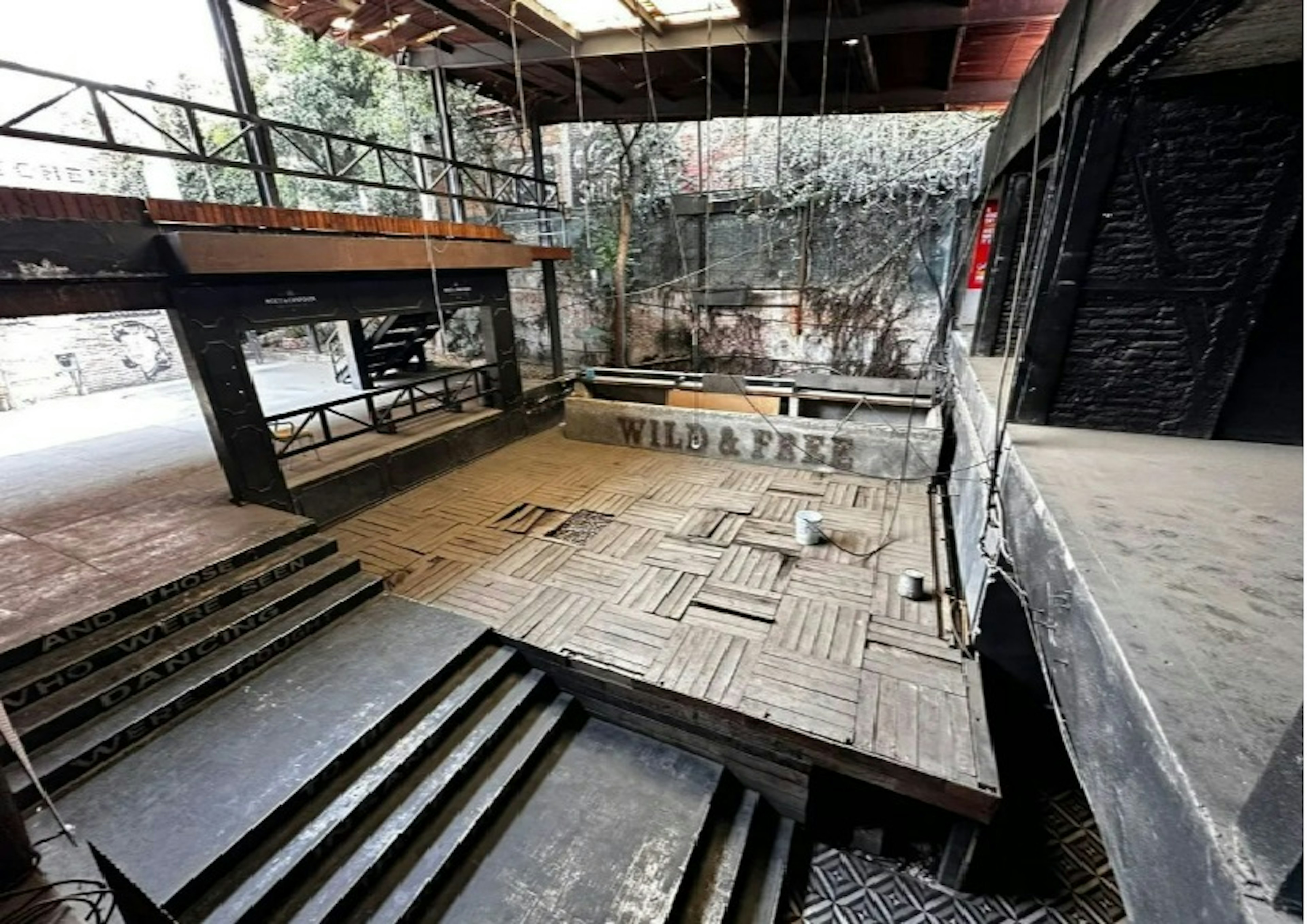 Espacio industrial convertido en loft, con estructuras de metal, techos altos y una mezcla de materiales que incluyen madera y concreto. Ambiente urbano y moderno.