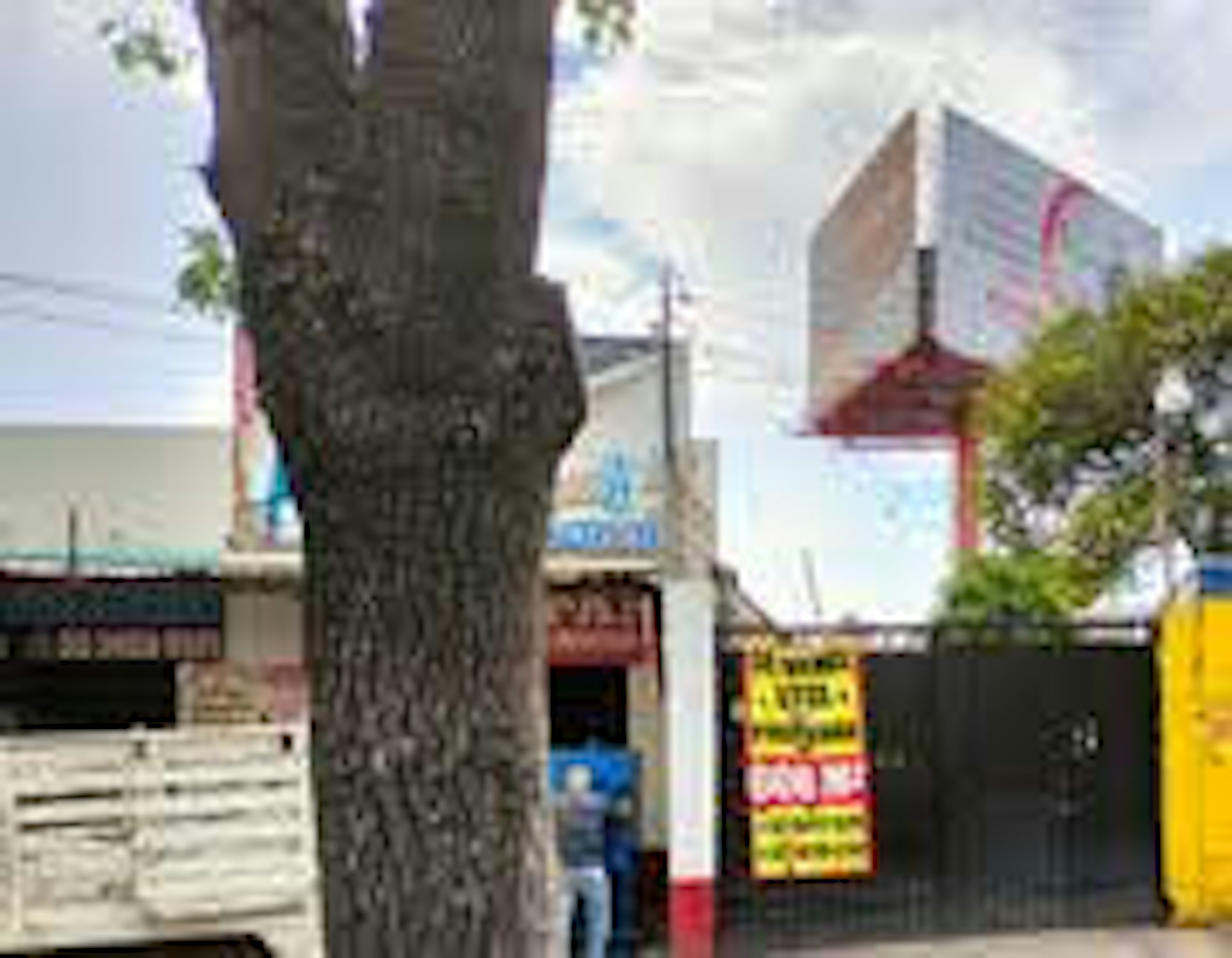 La imagen muestra una propiedad con un cartel de SE VENDE y SE ALQUILA, indicando que el inmueble está disponible tanto para la venta como para el arrendamiento. La propiedad está cerrada con un portón negro y tiene un árbol en frente.