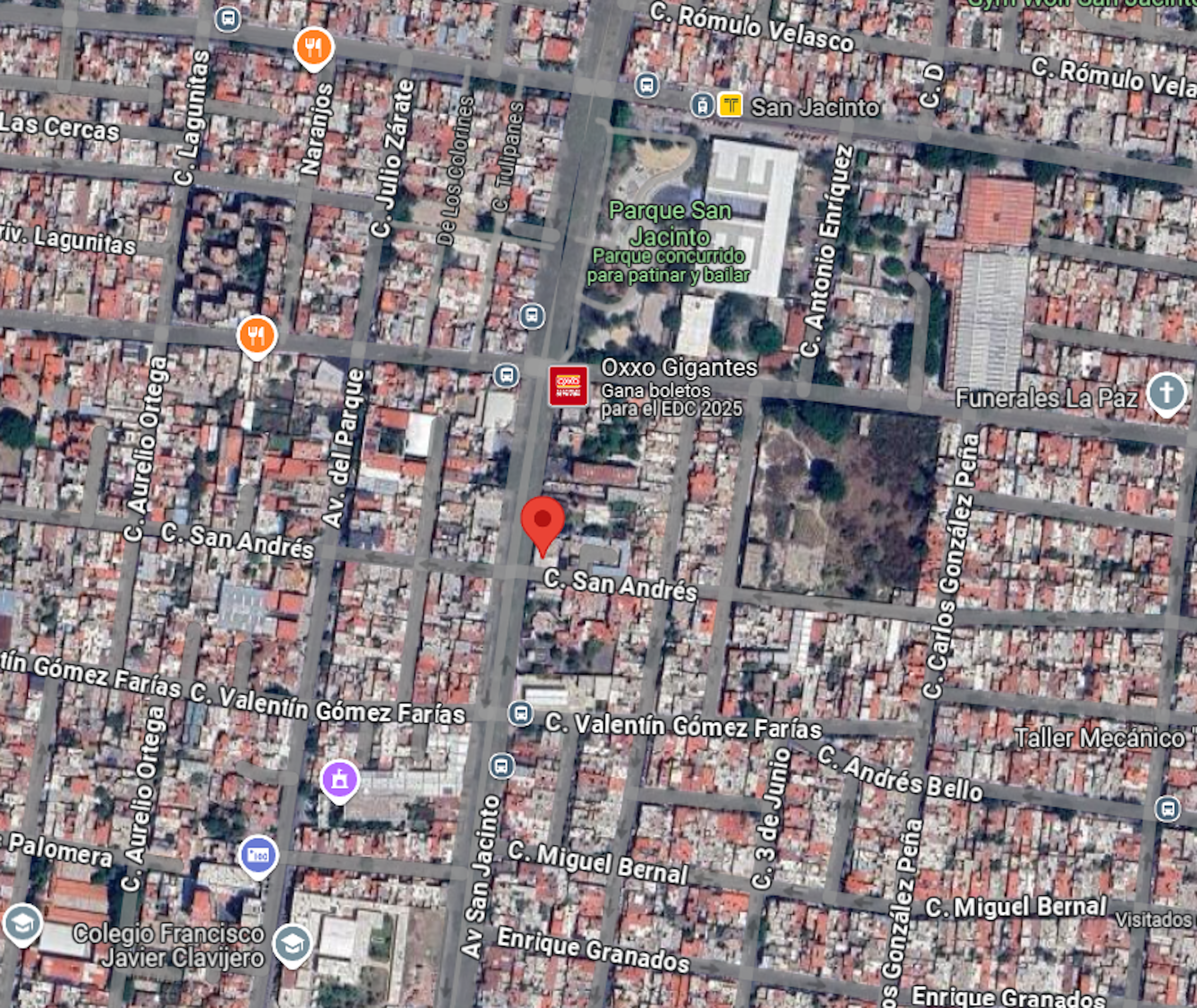 La imagen muestra un mapa satelital de una zona urbana densamente poblada. Se observan numerosas calles y manzanas con edificaciones de techo rojo. Destaca un parque llamado Parque San Jacinto y varios puntos de interés como un Oxxo y una funeraria. La zona parece ser residencial con una mezcla de comercios. El diseño de las calles sugiere una planificación urbana organizada en cuadrícula.