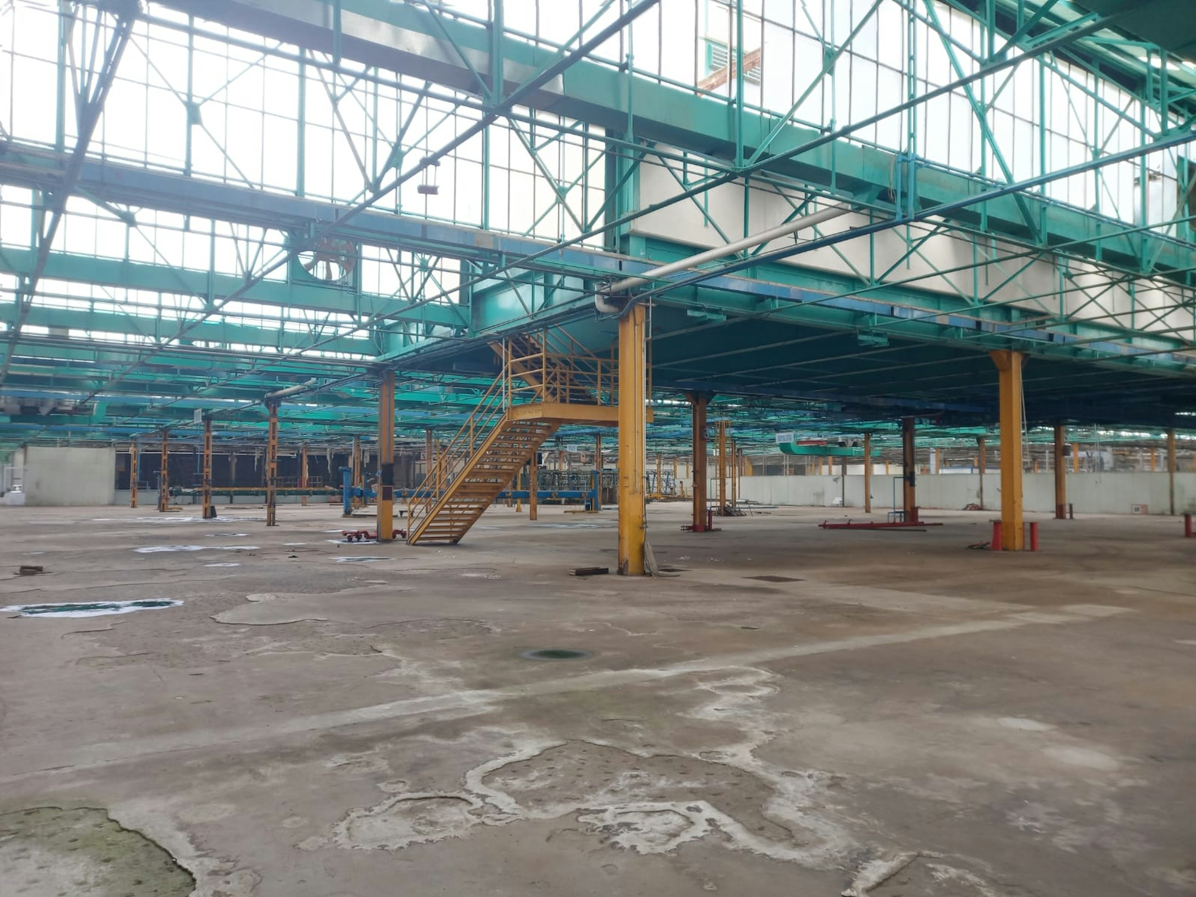 Espacio industrial amplio y vacío con estructura de acero y techo alto. Ideal para manufactura o almacenaje. Requiere mantenimiento y limpieza.