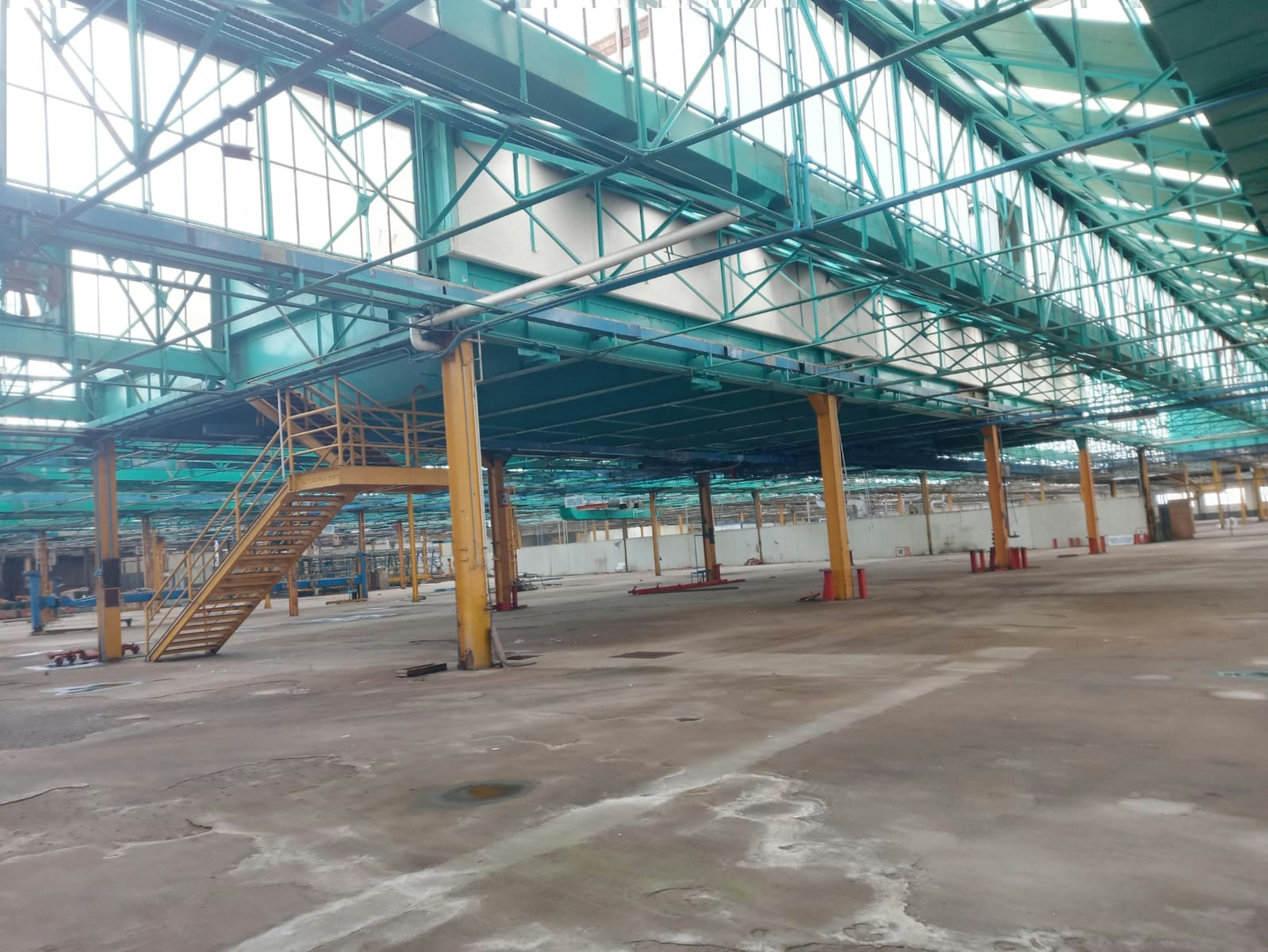 Espacio industrial amplio con estructura de acero y techos altos. Ideal para operaciones de manufactura o almacenaje, con buena iluminación natural y acceso para carga y descarga.