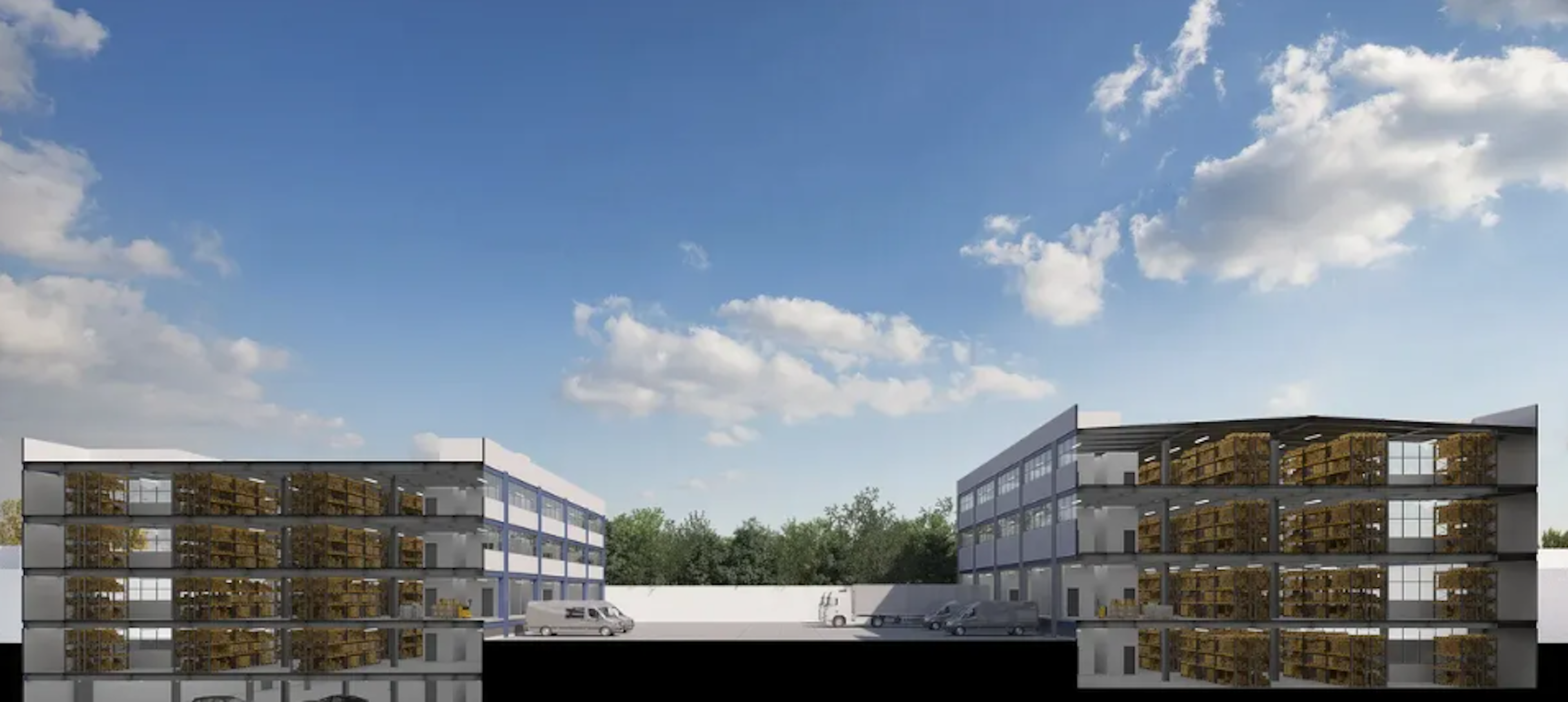La imagen muestra un complejo de almacenamiento moderno con dos edificios de varios pisos. Cada edificio tiene múltiples niveles visibles con unidades de almacenamiento llenas de cajas y materiales. El diseño es industrial pero elegante, con fachadas de vidrio que permiten ver el interior. En el centro hay un área de estacionamiento con algunos vehículos. El cielo azul con nubes blancas proporciona un fondo agradable, sugiriendo un entorno suburbano o industrial bien mantenido.