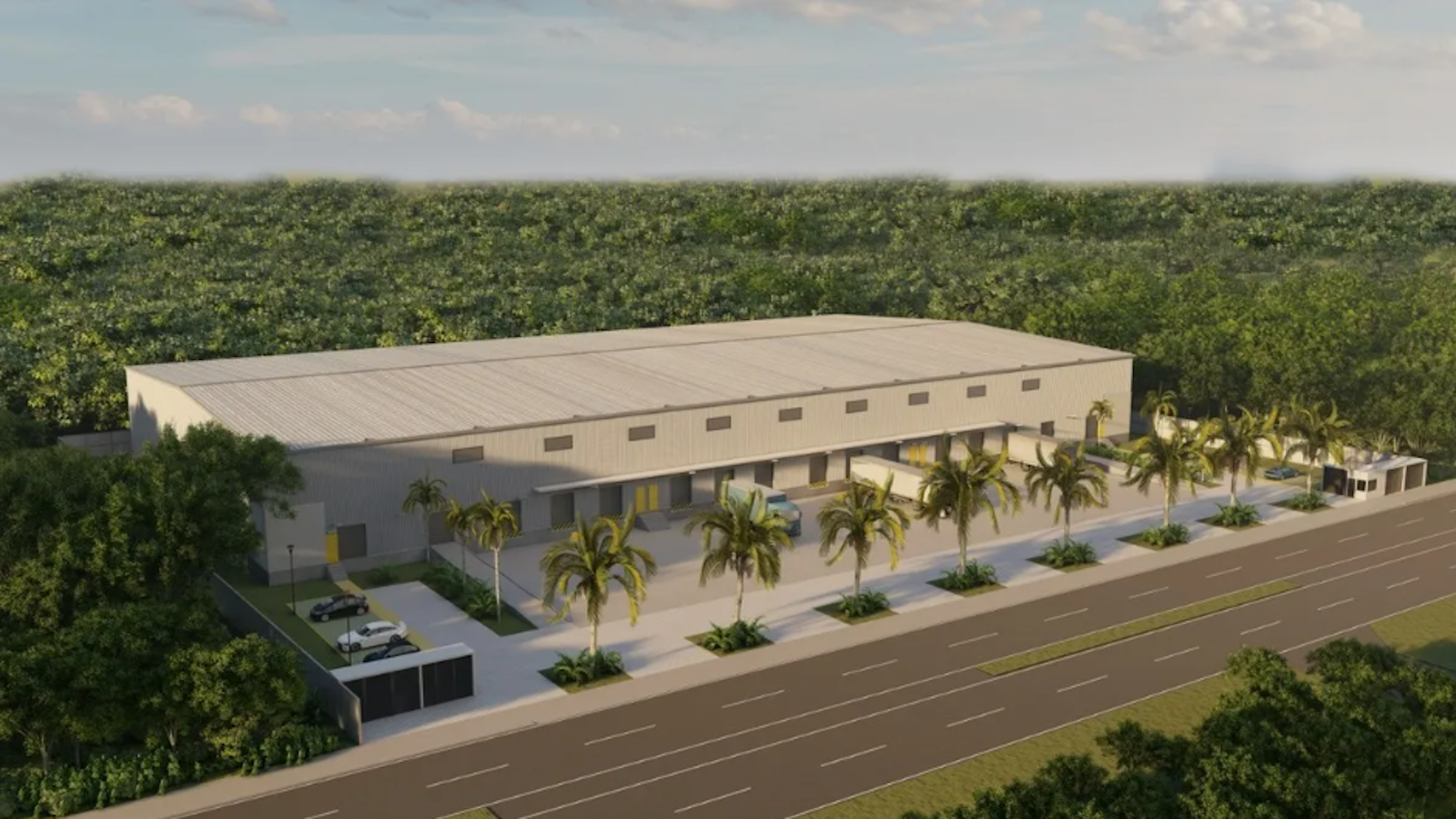 La imagen muestra un render arquitectónico de un almacén o nave industrial moderna. El edificio es grande y rectangular, con un techo plano y múltiples puertas de carga. Está rodeado de palmeras y vegetación tropical, con un amplio estacionamiento y una carretera de varios carriles al frente. El diseño sugiere una ubicación en un área cálida, posiblemente cerca de un bosque o selva. La estructura parece nueva y bien diseñada para operaciones logísticas o industriales.
