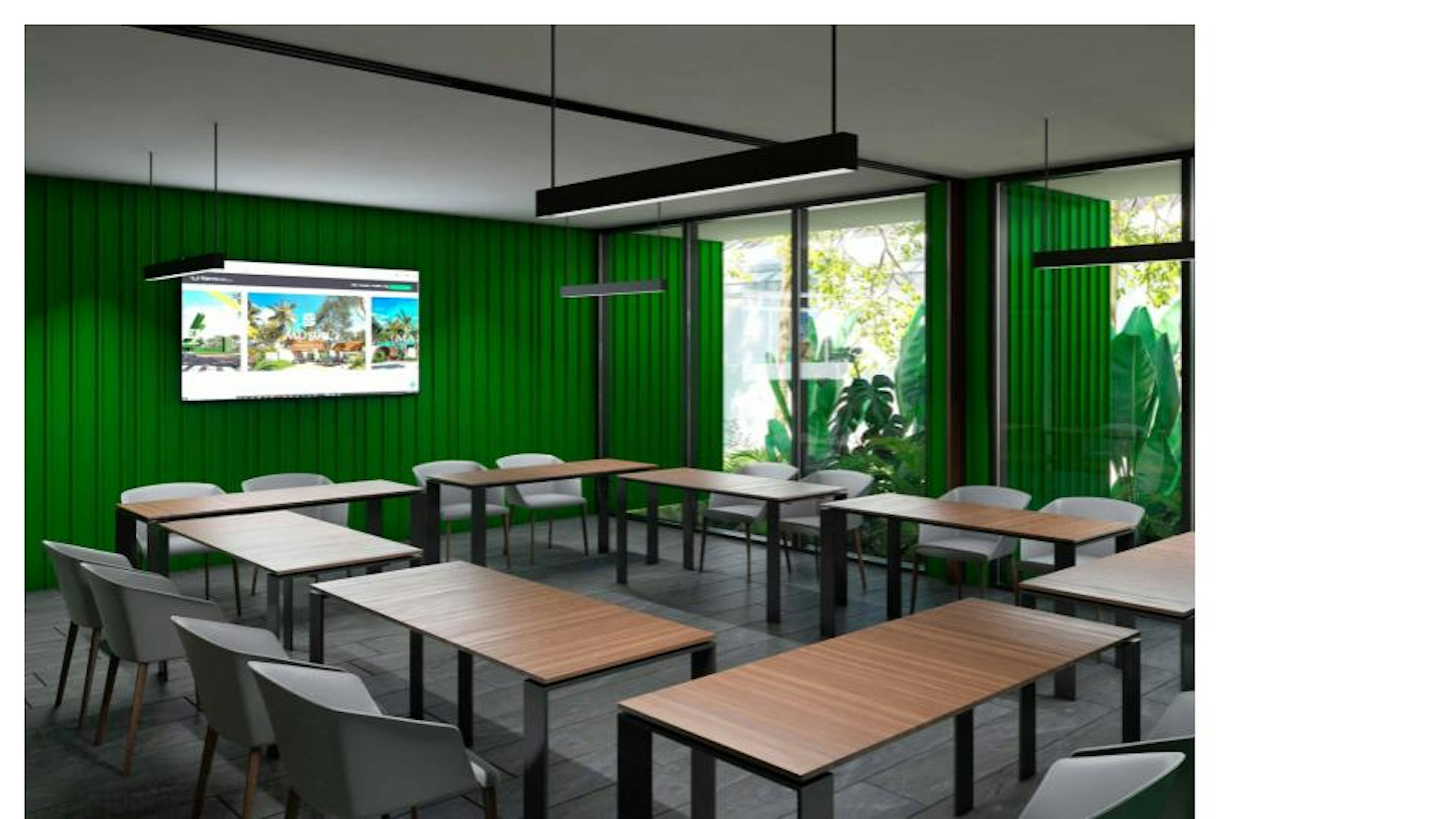 This image shows a modern conference or training room with vibrant green walls and large windows. The space is furnished with wooden tables arranged in a U-shape, complemented by grey chairs. A large flat-screen display is mounted on the wall, and sleek pendant lighting hangs from the ceiling. The room has a fresh, nature-inspired feel with plants visible through the windows, creating an inviting environment for meetings or educational sessions.